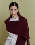 Alpaka-Oversize-Schal Gabriela in Berry über einer weißen Bluse – Vorderansicht der breiten Strickfläche.