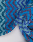 Detail des Alpaka-Schals ZigZag in Türkis mit Zickzackmuster in Blau-, Türkis- und Violetttönen.