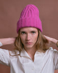 Baby-Alpaka-Mütze in Fuchsia von Manuela Bedford – am Model mit hochgezogener Spitze.