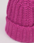 Baby-Alpaka-Mütze in Fuchsia von Manuela Bedford – Nahaufnahme der Strickstruktur und des umgeschlagenen Bündchens.