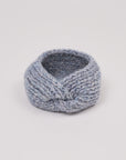Gestricktes Stirnband in Grau von Manuela Bedford – aufgestellt mit gedrehter Vorderseite.