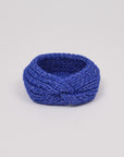 Gestricktes Stirnband in Königsblau von Manuela Bedford – aufgestellt mit gedrehter Vorderseite.