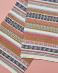 Alpaka-Schal Rayas in Grün mit bunten Musterstreifen von Manuela Bedford – Detail des Streifenmusters.