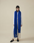 Oversize-Schal aus Merino-Alpaka-Mix in Blau von Manuela Bedford – am Model, Gesamtansicht mit langen Fransen.