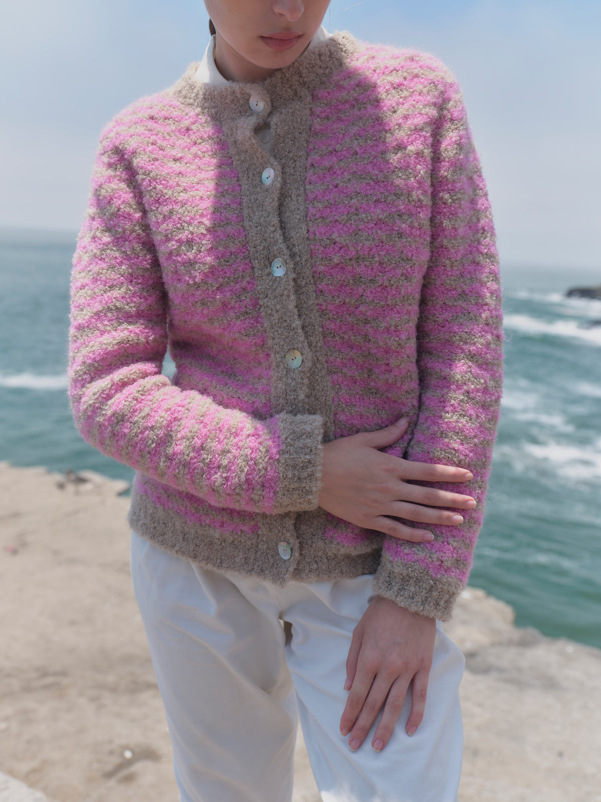 Rosa-beige gestreifte Bouclé-Strickjacke Cruz mit beiger Knopfleiste, Stehkragen und Bündchen in der Vorderansicht.