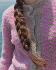Detail der rosa-beigen Bouclé-Strickjacke Cruz: strukturierter Strick, beiger Stehkragen und helle Knöpfe.