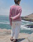 Rückansicht der Alpaka-Bouclé-Strickjacke Cruz in Rosa und Beige mit Streifenmuster und beigem Saum.