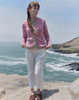 Alpaka-Bouclé-Strickjacke Cruz in Rosa und Beige von Manuela Bedford, Vorderansicht am Model mit weißer Hose.