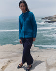 Alpaka-Bouclé-Strickjacke Cruz in Türkis von Manuela Bedford, Vorderansicht am Model mit dunklem Rock.