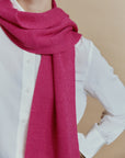 Nahaufnahme des Alpaka-Schals Klassik in Fuchsia mit lockerem Umschlag am Hals und feiner Strickstruktur.