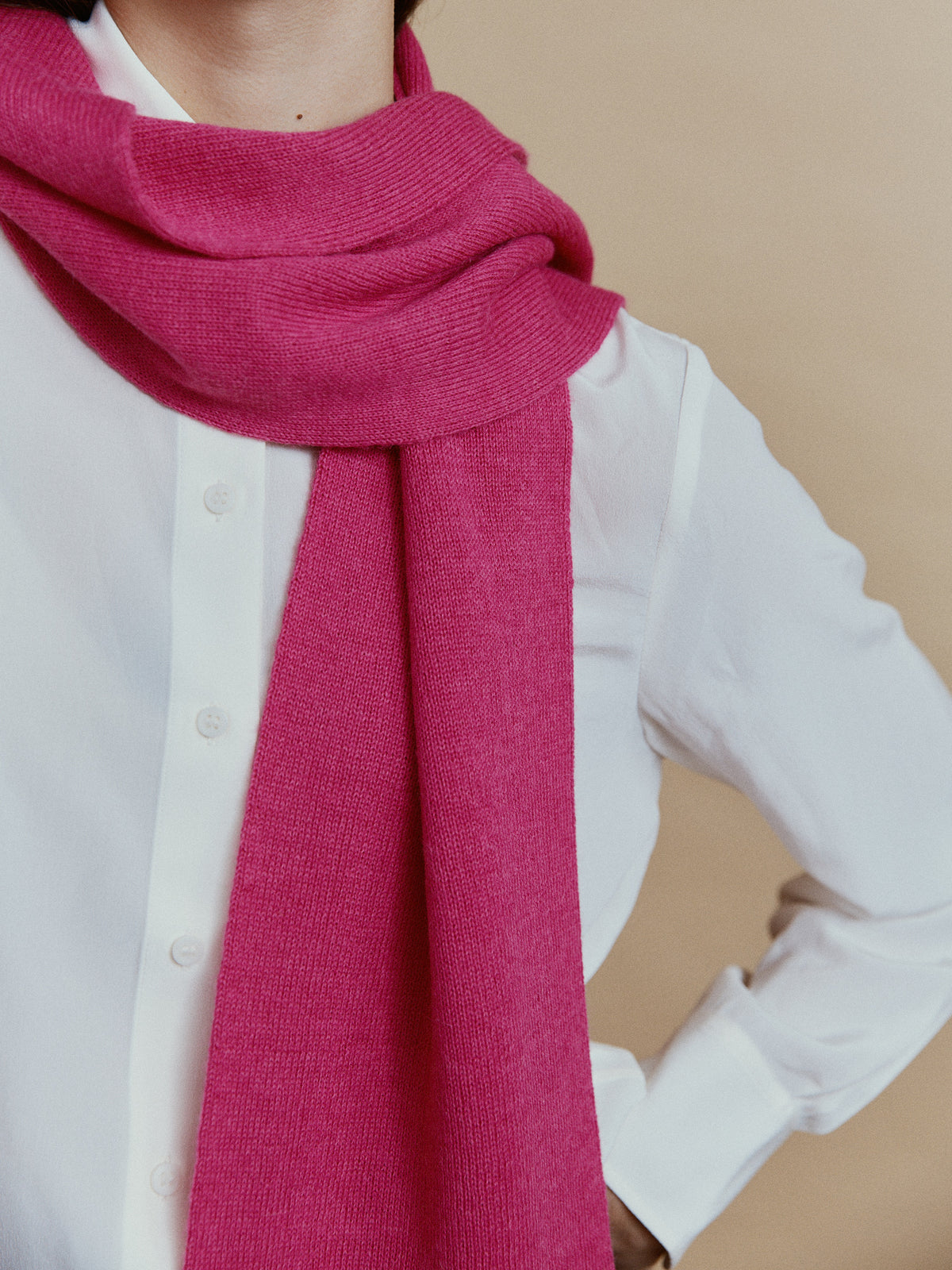 Nahaufnahme des Alpaka-Schals Klassik in Fuchsia mit lockerem Umschlag am Hals und feiner Strickstruktur.