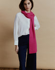 Alpaka-Schal Klassik in Fuchsia mit langem Schalende über einer weißen Bluse – schräge Vorderansicht.
