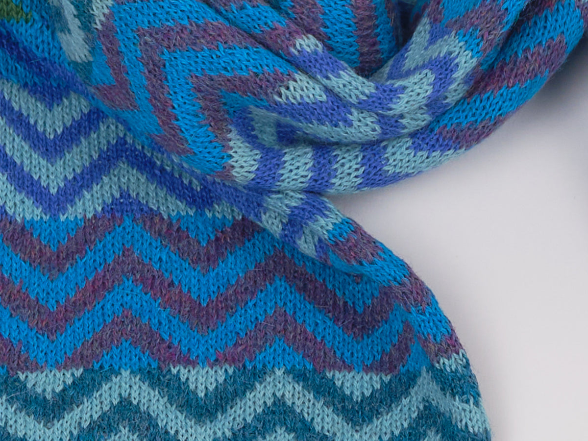 Detail des Alpaka-Schals ZigZag in Türkis mit Zickzackmuster in Blau-, Türkis- und Violetttönen.
