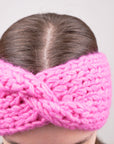 Alpaka-Stirnband Vero in Fuchsia an einer Frau – Frontansicht der gedrehten Vorderseite.