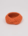 Alpaka-Stirnband Vero in Orange – freigestellte Produktansicht mit gedrehter Vorderseite.