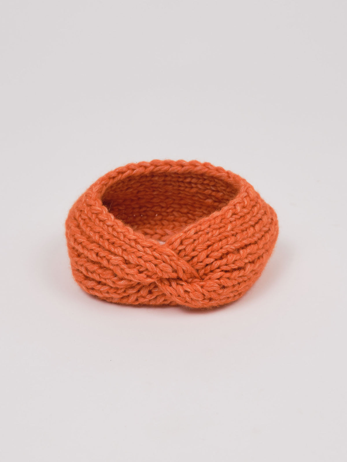 Alpaka-Stirnband Vero in Orange – freigestellte Produktansicht mit gedrehter Vorderseite.