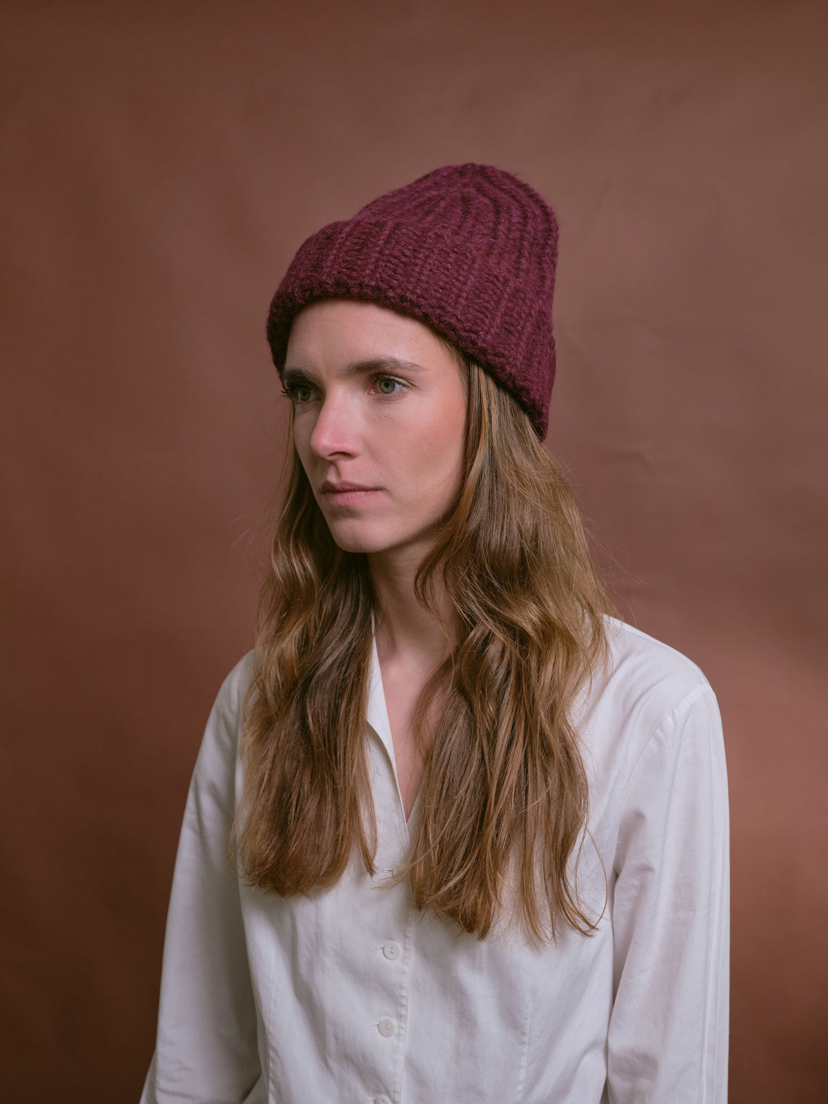 Baby-Alpaka-Mütze in Berry von Manuela Bedford – am Model, seitliche Ansicht.