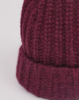 Baby-Alpaka-Mütze in Berry von Manuela Bedford – Nahaufnahme der Strickstruktur und des umgeschlagenen Bündchens.