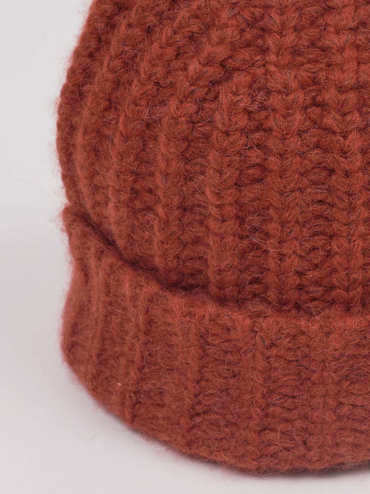 Baby-Alpaka-Mütze in Braun von Manuela Bedford – Nahaufnahme der Strickstruktur und des umgeschlagenen Bündchens.