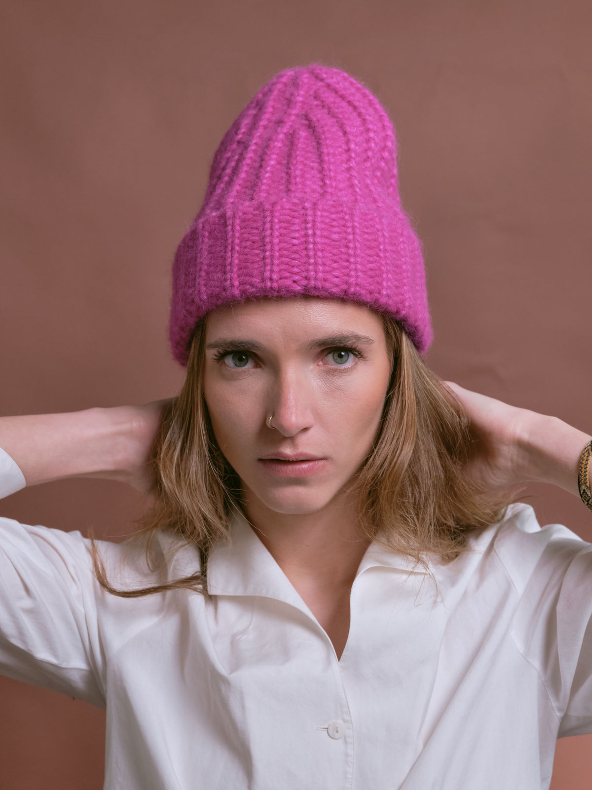 Baby-Alpaka-Mütze in Fuchsia von Manuela Bedford – am Model mit hochgezogener Spitze.