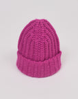 Baby-Alpaka-Mütze in Fuchsia von Manuela Bedford – aufgestellt mit umgeschlagenem Bündchen.