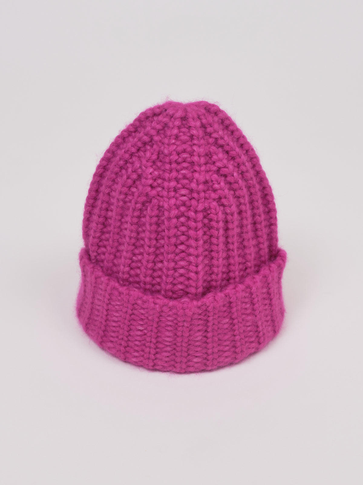 Baby-Alpaka-Mütze in Fuchsia von Manuela Bedford – aufgestellt mit umgeschlagenem Bündchen.