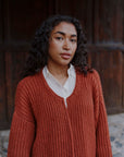 Porträt mit der offenen Strickjacke Tinki aus Baby Alpaka in Braun von Manuela Bedford.