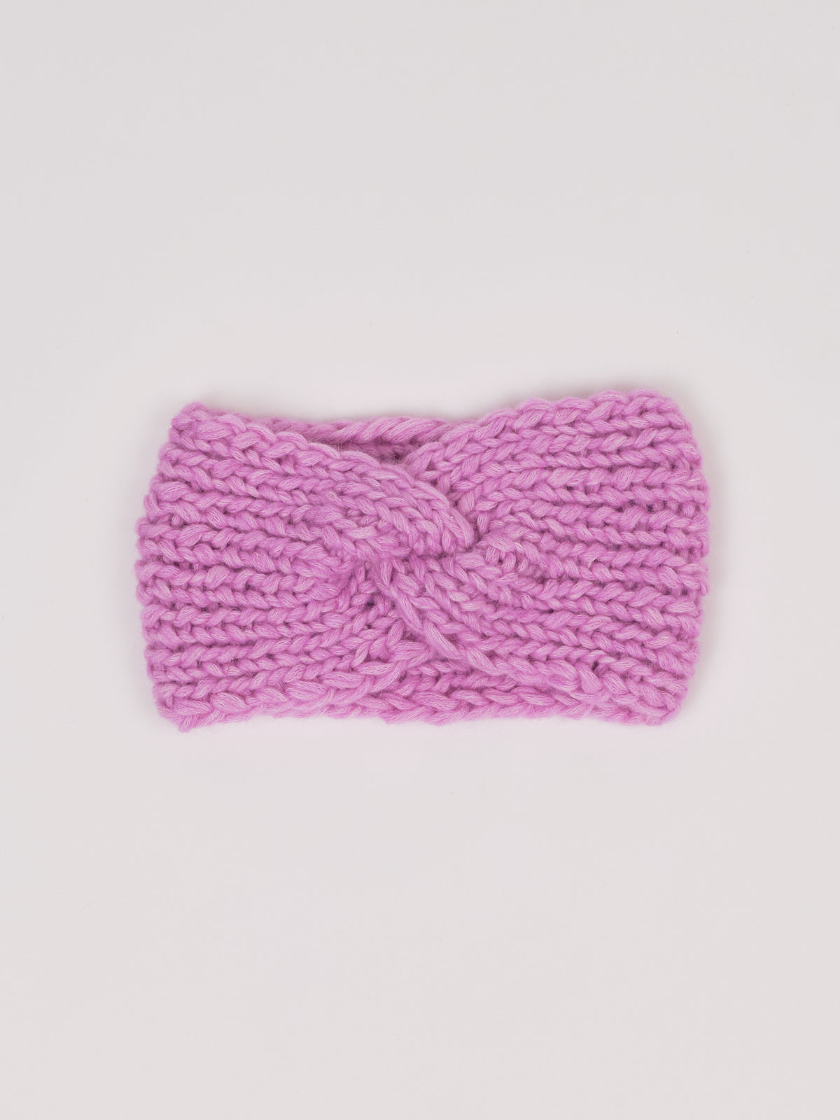 Gestricktes Stirnband in Flieder von Manuela Bedford – flach ausgelegt mit gedrehter Vorderseite.