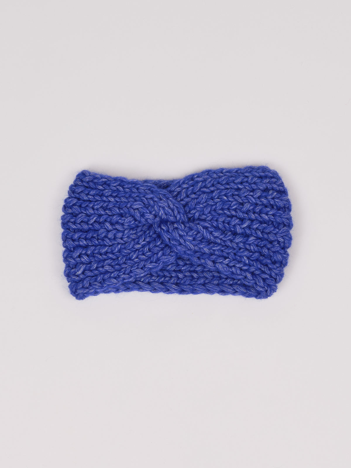 Gestricktes Stirnband in Königsblau von Manuela Bedford – flach ausgelegt mit gedrehter Vorderseite.