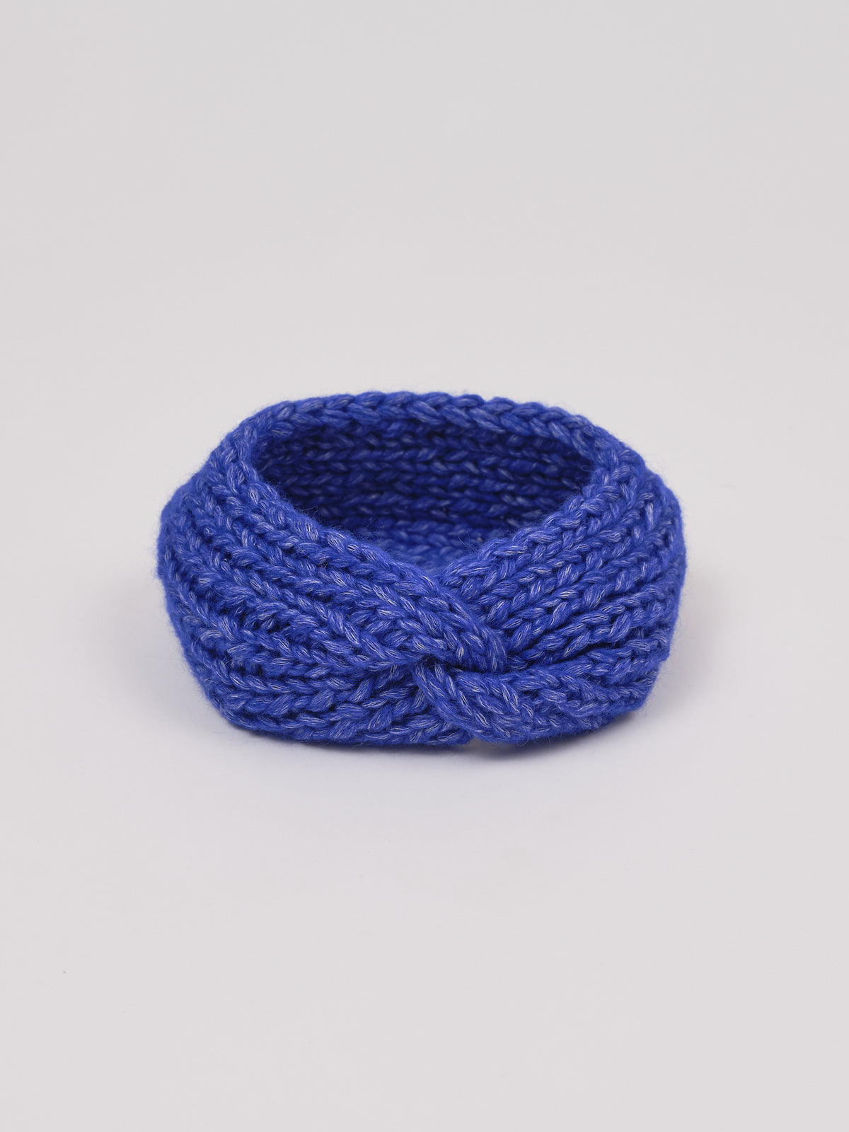Gestricktes Stirnband in Königsblau von Manuela Bedford – aufgestellt mit gedrehter Vorderseite.