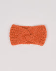 Gestricktes Stirnband in Orange von Manuela Bedford – flach ausgelegt mit gedrehter Vorderseite.