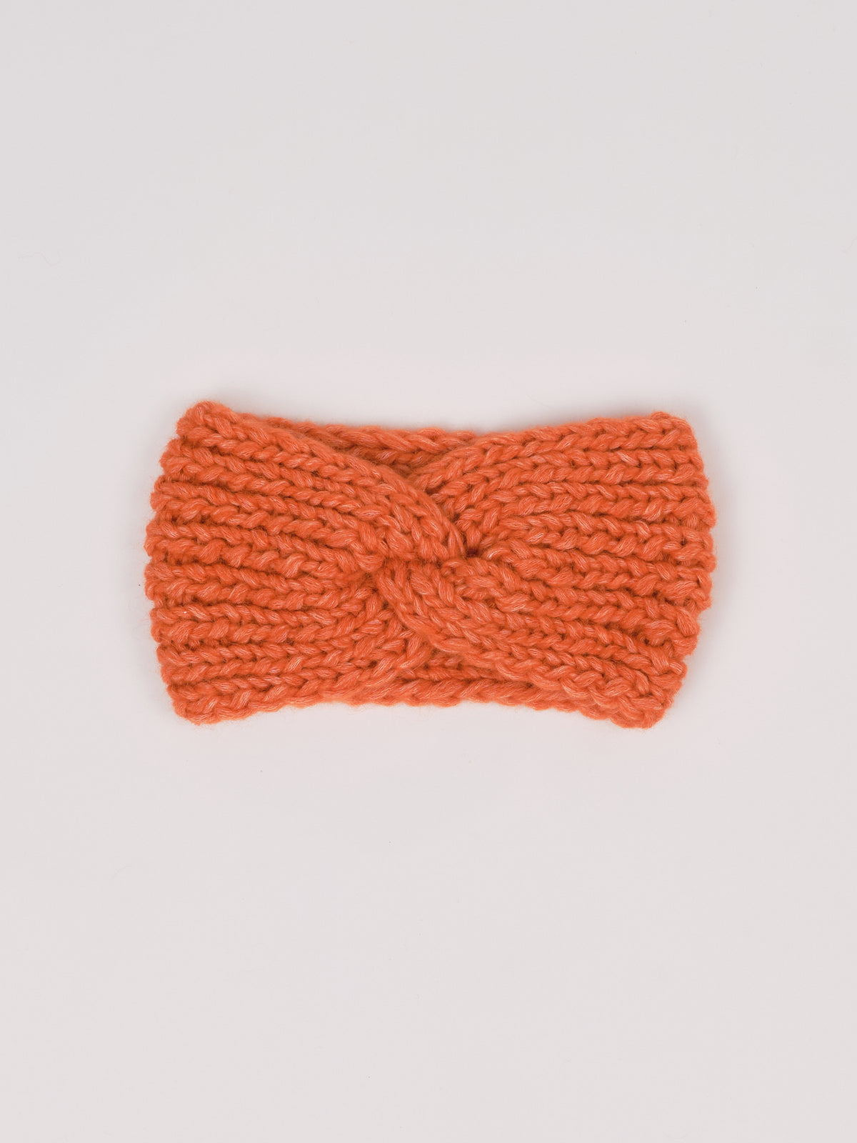 Gestricktes Stirnband in Orange von Manuela Bedford – flach ausgelegt mit gedrehter Vorderseite.