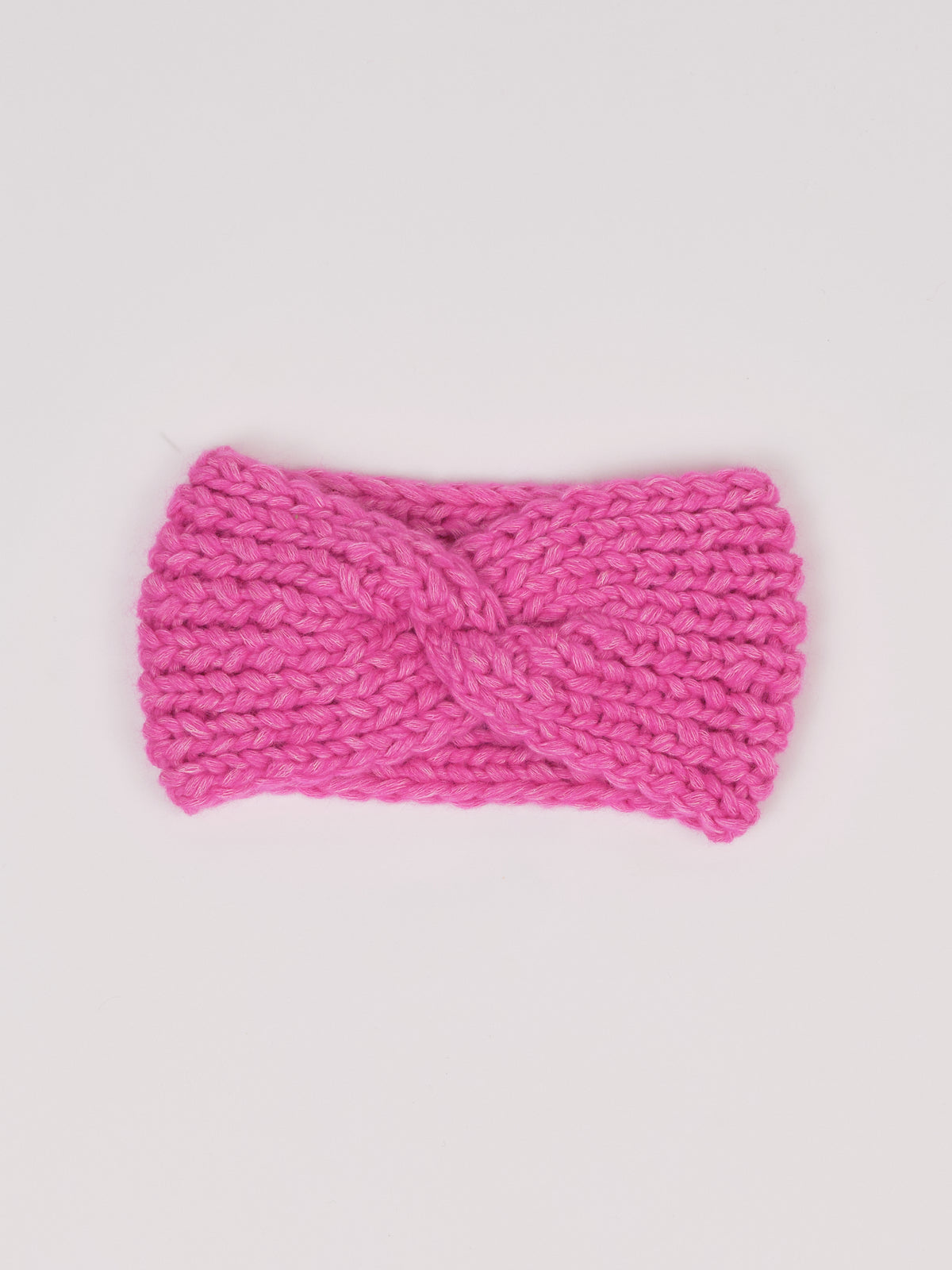 Gestricktes Stirnband in Pink von Manuela Bedford – flach ausgelegt mit gedrehter Vorderseite.