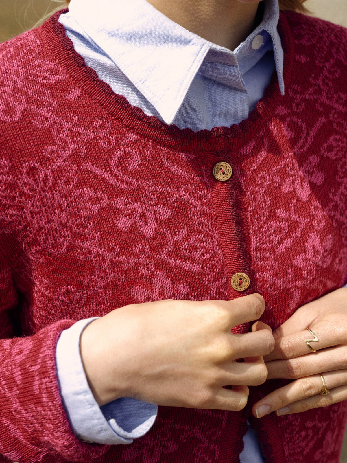 Alpaka-Cardigan Camila in Fuchsia von Manuela Bedford – Nahaufnahme von Muster und Knopfleiste am Model.